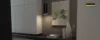 Elegante zona giorno con armadi bianchi e decorazioni, Nolte Living.