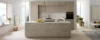 Cucina moderna con grande isola e armadi chiari, circondata da ampie finestre, Nolte Kitchen.