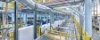 Impianto di produzione moderno con strutture metalliche e nastri trasportatori in un ambiente industriale.