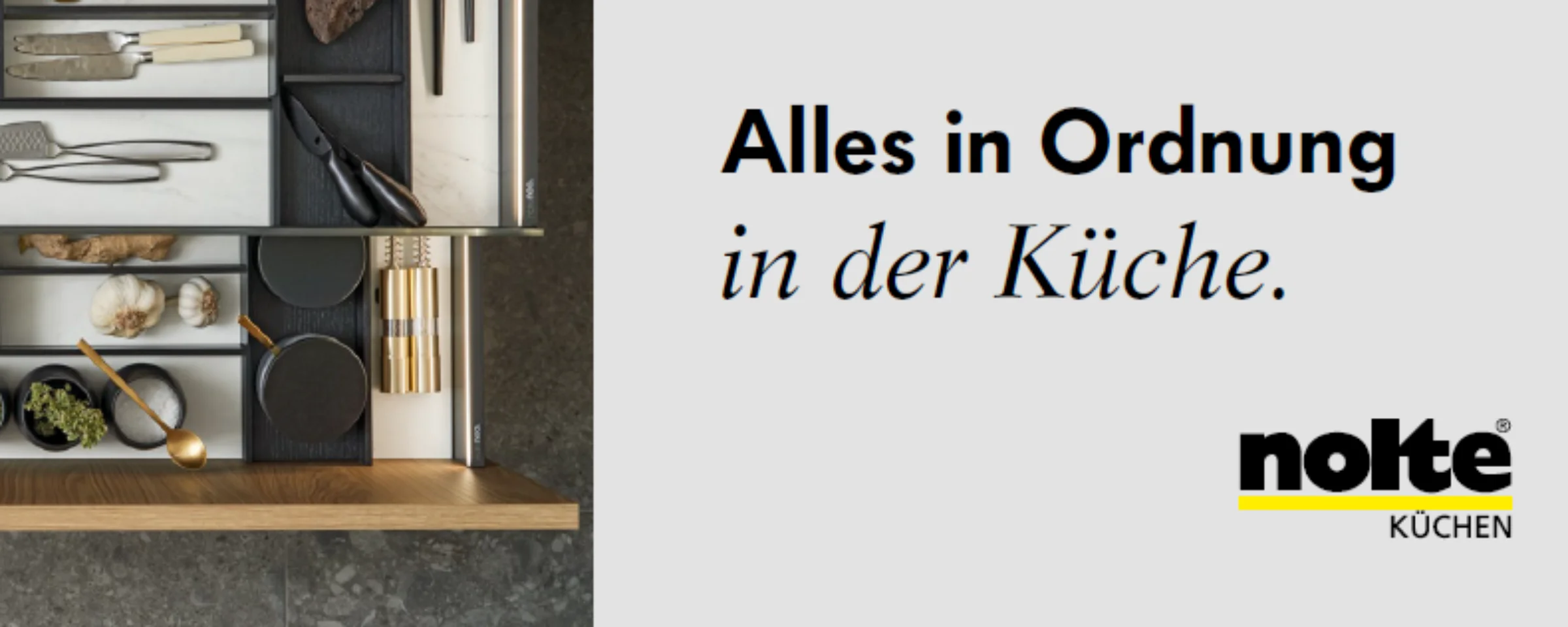 An open kitchen drawer reveals neatly organized cutlery and utensils, perfectly arranged with Nolte Kitchen.
