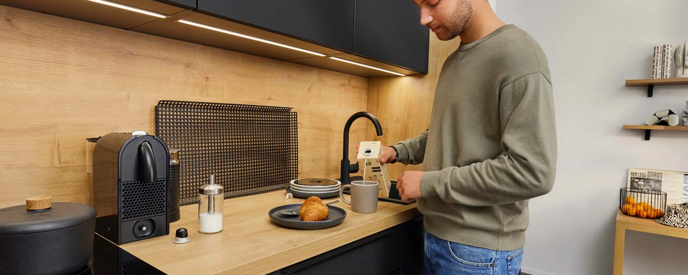 Un uomo prepara il caffè in una cucina moderna di Nolte Kitchen.