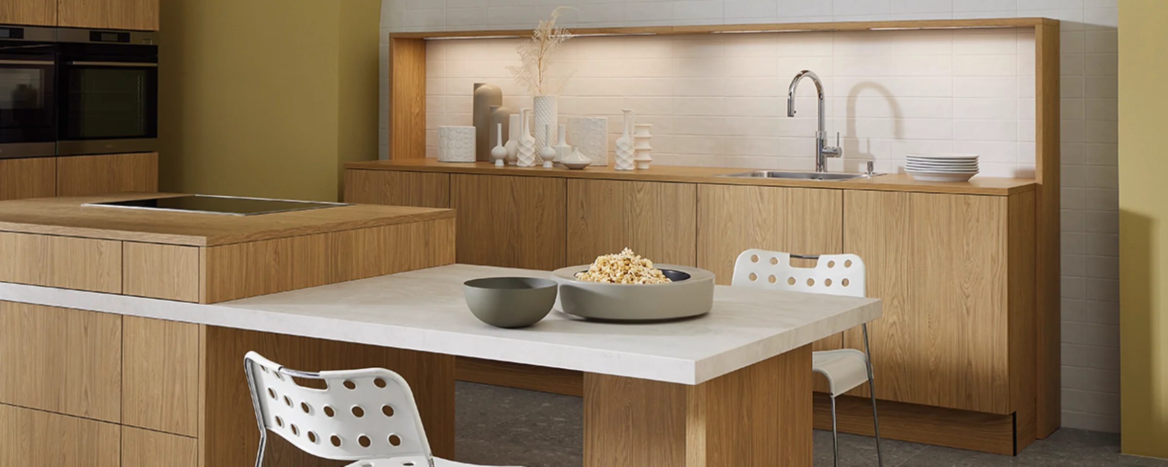 Cucina moderna con frontali in legno e tavolo da pranzo integrato di Nolte Kitchen.