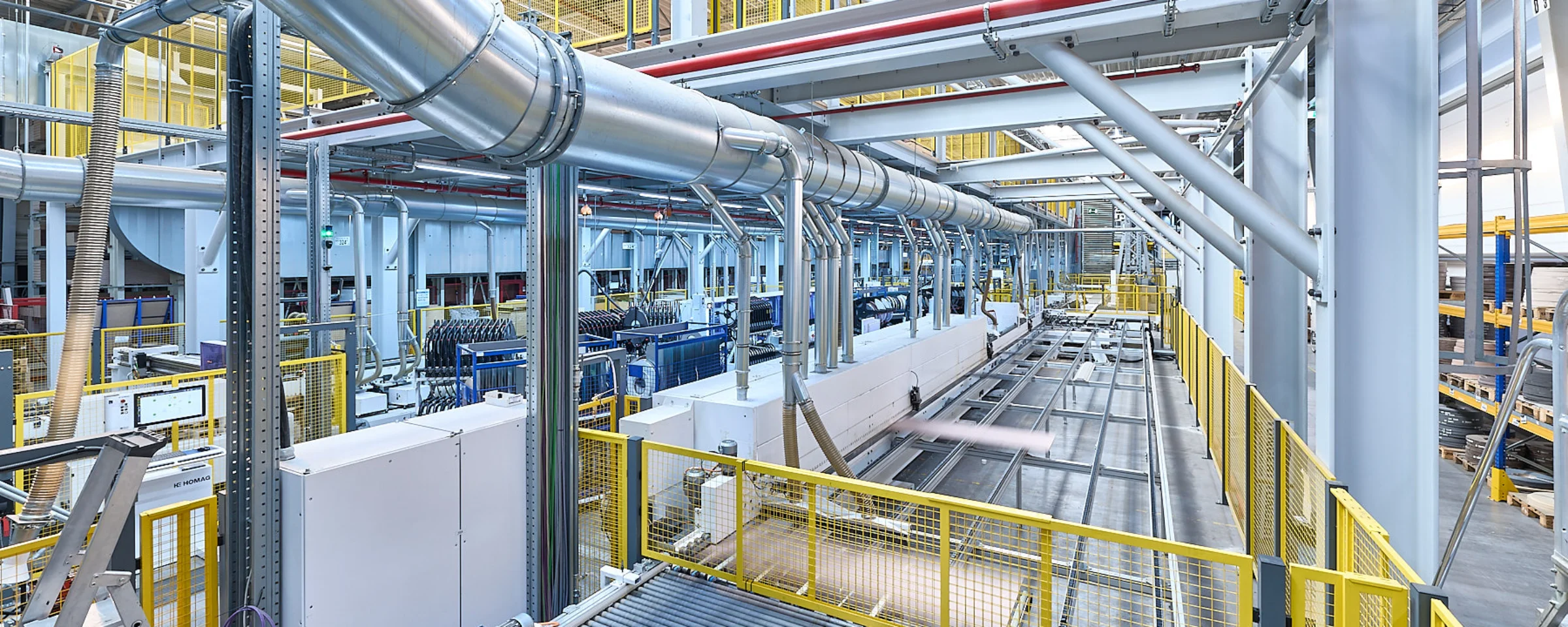 Impianto di produzione moderno con strutture metalliche e nastri trasportatori in un ambiente industriale.