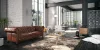 Elegante zona giorno con divano in pelle marrone e tappeto, arredamento moderno di Nolte Living.