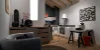 Stilvolmente arredata cucina tiny sotto le falde del tetto con il programma di frontali FEEL in bianco opaco e piano di lavoro STONE in cemento a contrasto. Progettazione compatta con area living e lavorativa in un unico spazio.