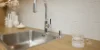 Cucina moderna con piano in legno e lavello in acciaio inox di Nolte Kitchen.