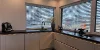 Modern kitchen with large windows and dark countertops. Nolte Kitchen.