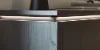 Moderno sideboard in legno scuro con illuminazione, libri e decorazioni sopra, di Nolte Living.