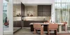 Moderna cucina Nolteneo con frontale neoMIRROR in finish a specchio e frontale Soft Lack in seppia marrone. Armadi senza maniglie, piano di lavoro color pietra e tavolo da pranzo rotondo con sedie imbottite in un ambiente elegante e pieno di luce.