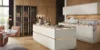 Cucina moderna con armadi bianchi e dettagli in legno di Nolte Kitchen.