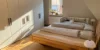 Camera da letto con letto matrimoniale e armadio, illuminata dalla luce solare, di Nolte Living.
