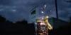 Un bicchiere con stelle filanti e un nastro giallo davanti a un cartello di notte.