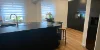 Cucina moderna con armadi scuri e pavimento in legno, arredata da Nolte Kitchen.