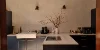 Cucina moderna con isola e armadi scuri, illuminata da un lampadario. Nolte Kitchen.