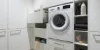 Moderna lavanderia con lavatrice e spazio di archiviazione, progettata da Nolte Utility Rooms.