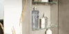 Un armadietto da bagno aperto con prodotti per la cura accanto a un vaso con erbe. Nolte SPA.