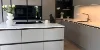 Cucina moderna con armadi grigi e isola centrale. Cucine Nolte.