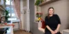 Una donna siede in una cucina moderna con piante, design di Nolte Kitchen.