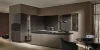 Elegante cucina Nolte con l'esclusiva frontale neoLODGE in Rovere annerito scanalato combinato con SOFT LACK in Magma softmatt. L'isola cucina senza maniglia con piano di lavoro scuro incontra elementi di vetrina illuminati di alta qualità e crea, in combinazione con gli elementi in legno strutturato, un'atmosfera elegante e accogliente in un design moderno.