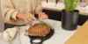 Una persona lega del rosmarino a un pane in una cucina moderna di Nolte Kitchen.