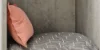 Cuscino grigio a righe bianche e cuscino rosa su uno scaffale. Nolte Living.