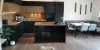 Cucina moderna con elementi in legno e nero, isola e tavolo; Nolte Kitchen.