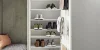 Scarpiera aperta con varie scarpe e area salotto, parte della collezione Nolte Living.