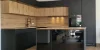 Cucina moderna con frontali scuri e in legno e un'isola di cottura di Nolte Kitchen.