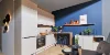 Cucina moderna con armadi bianchi e pareti blu, design di Nolte Kitchen.