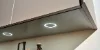 Bottiglie sotto un pensile illuminato; cucine Nolte.