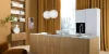 Cucina moderna Nolte con isola in legno, armadi bianchi e grandi finestre con lunghe tende gialle.