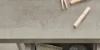 Eine Schublade mit Reinigungsutensilien aus Metall und Holzklammern auf Beton, Nolte Hauswirtschaftsraum.