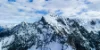 Snowy mountain landscape under a blue sky.