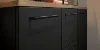 Elegante credenza nera con piano in legno e decorazioni, abbinata a Nolte Living.