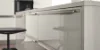 Cucina moderna con superfici lucide e sgabello da bar, Nolte Kitchen.