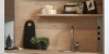 Cucina moderna con scaffali in legno e lavello, decorata con piante e accessori. Nolte Kitchen.
