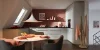 Cucina moderna con arredi bianchi e accenti rossi sotto un tetto spiovente, Nolte Kitchen.