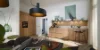Cucina moderna con frontali in legno e illuminazione elegante, tavolo da pranzo in primo piano. Nolte Kitchen.