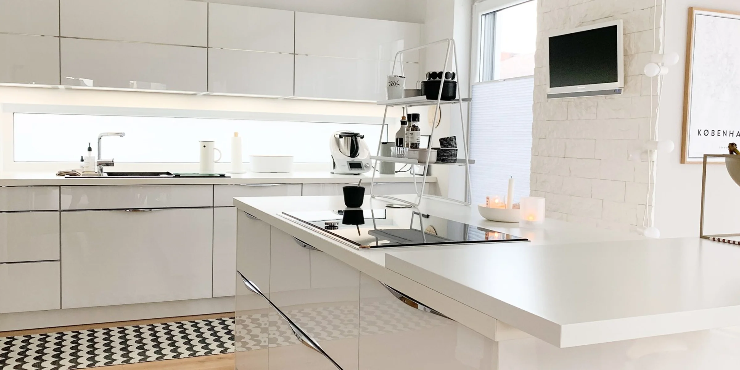 Cucina moderna con frontali bianchi lucidi e isola cottura, Nolte Kitchen.