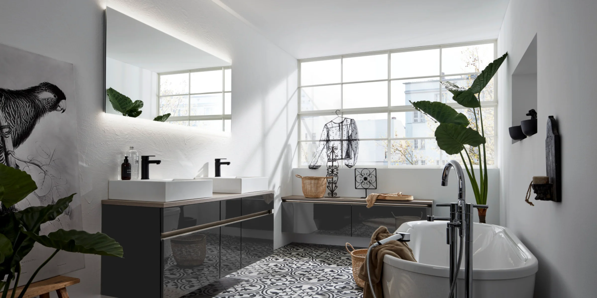 Bagno moderno con vasca e doppio lavabo, circondato da piante. Nolte SPA.