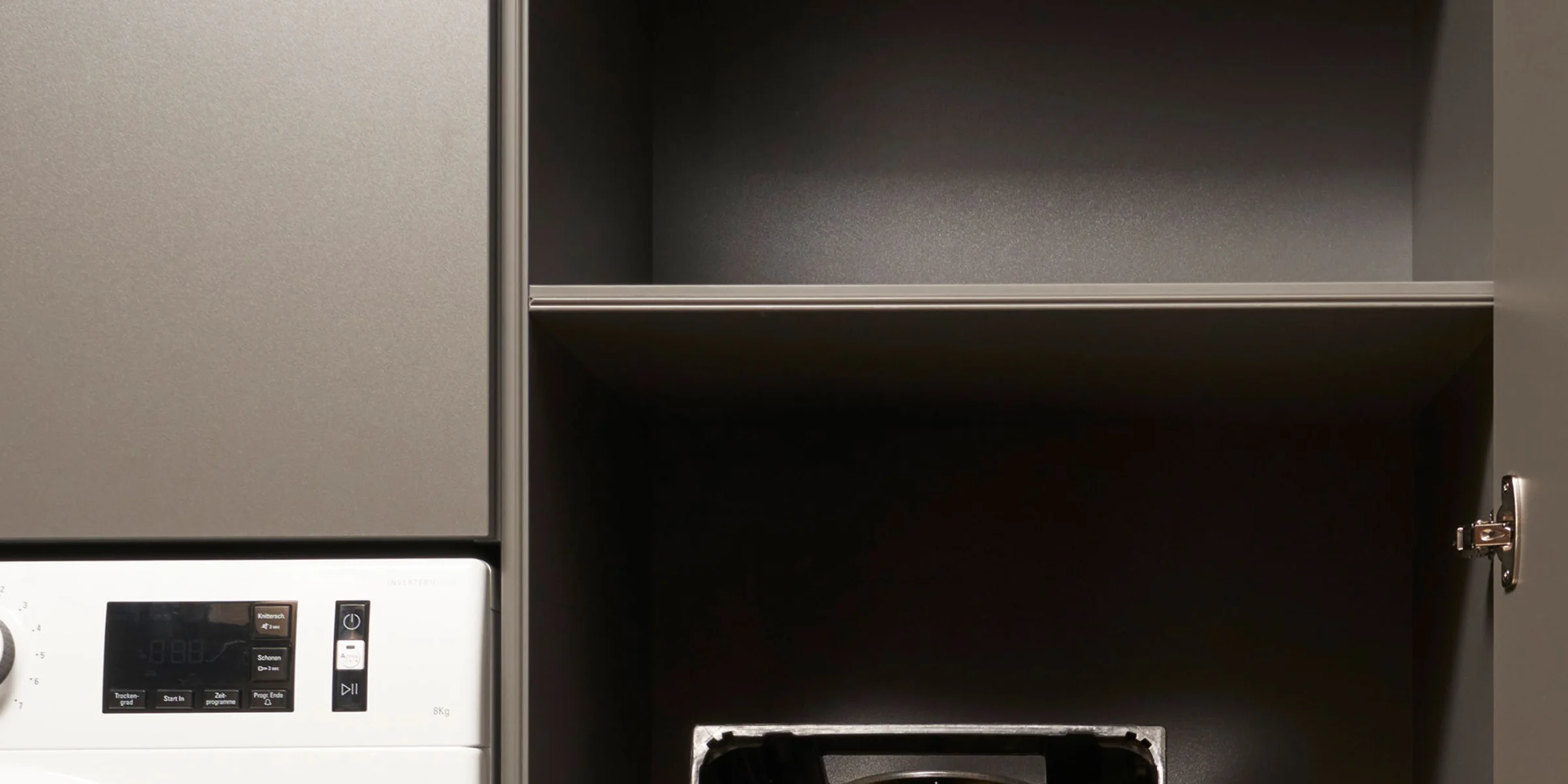 Locale lavanderia con lavatrice e scaffali, progettata da Nolte Utility Rooms.