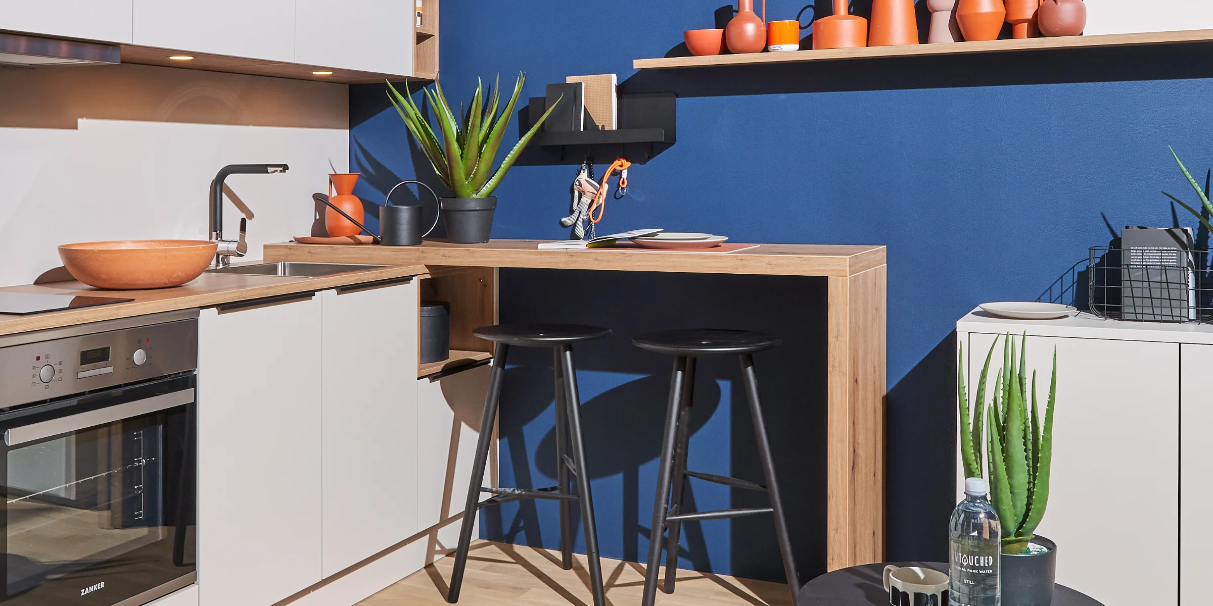 Cucina moderna con pareti blu e piante, progettata da Nolte Kitchen.