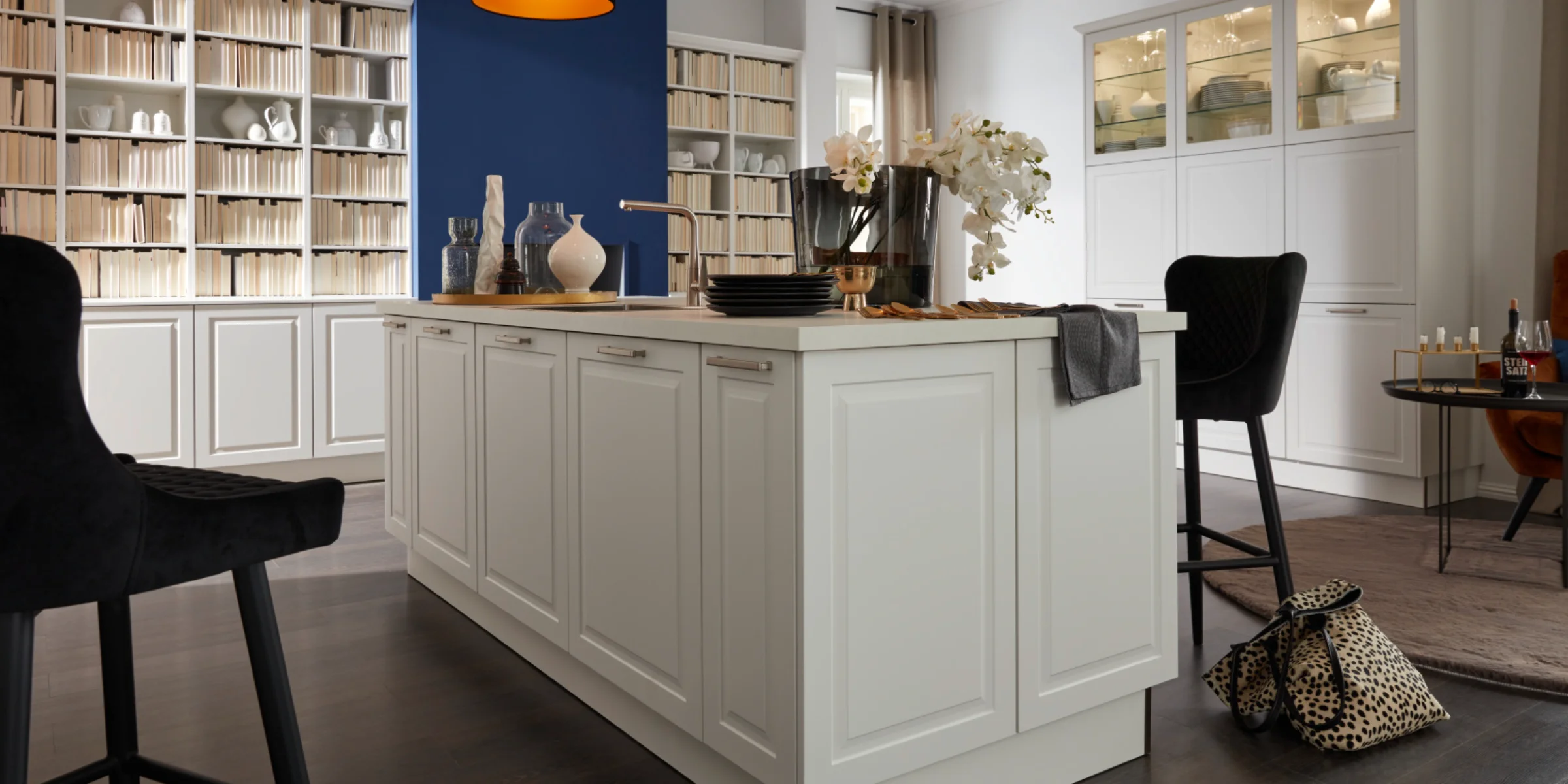 Cucina moderna con isola bianca e parete blu sullo sfondo, Nolte Kitchen.