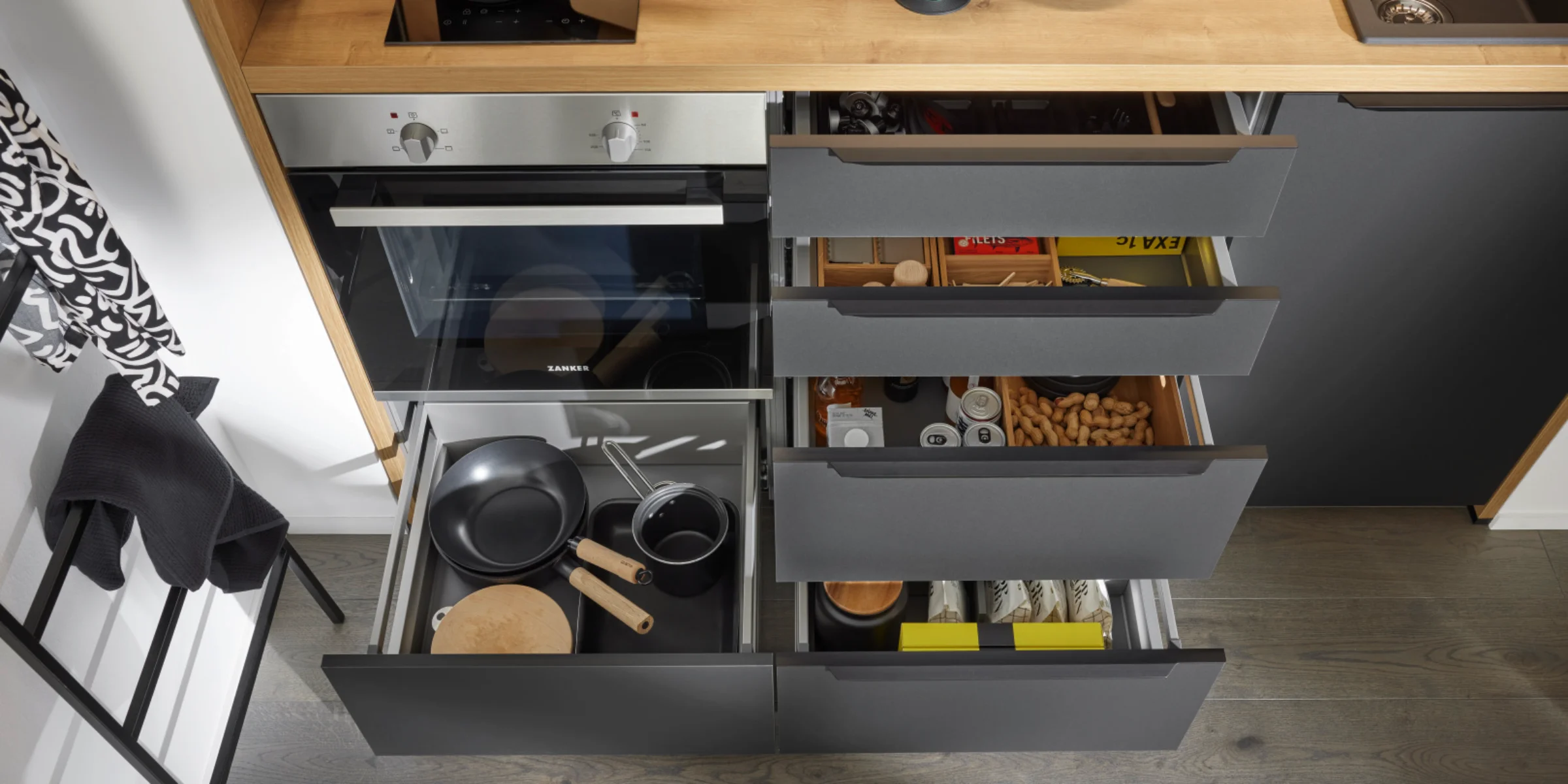 Cucina moderna con cassetti aperti e utensili da cucina, design di Nolte Kitchen.