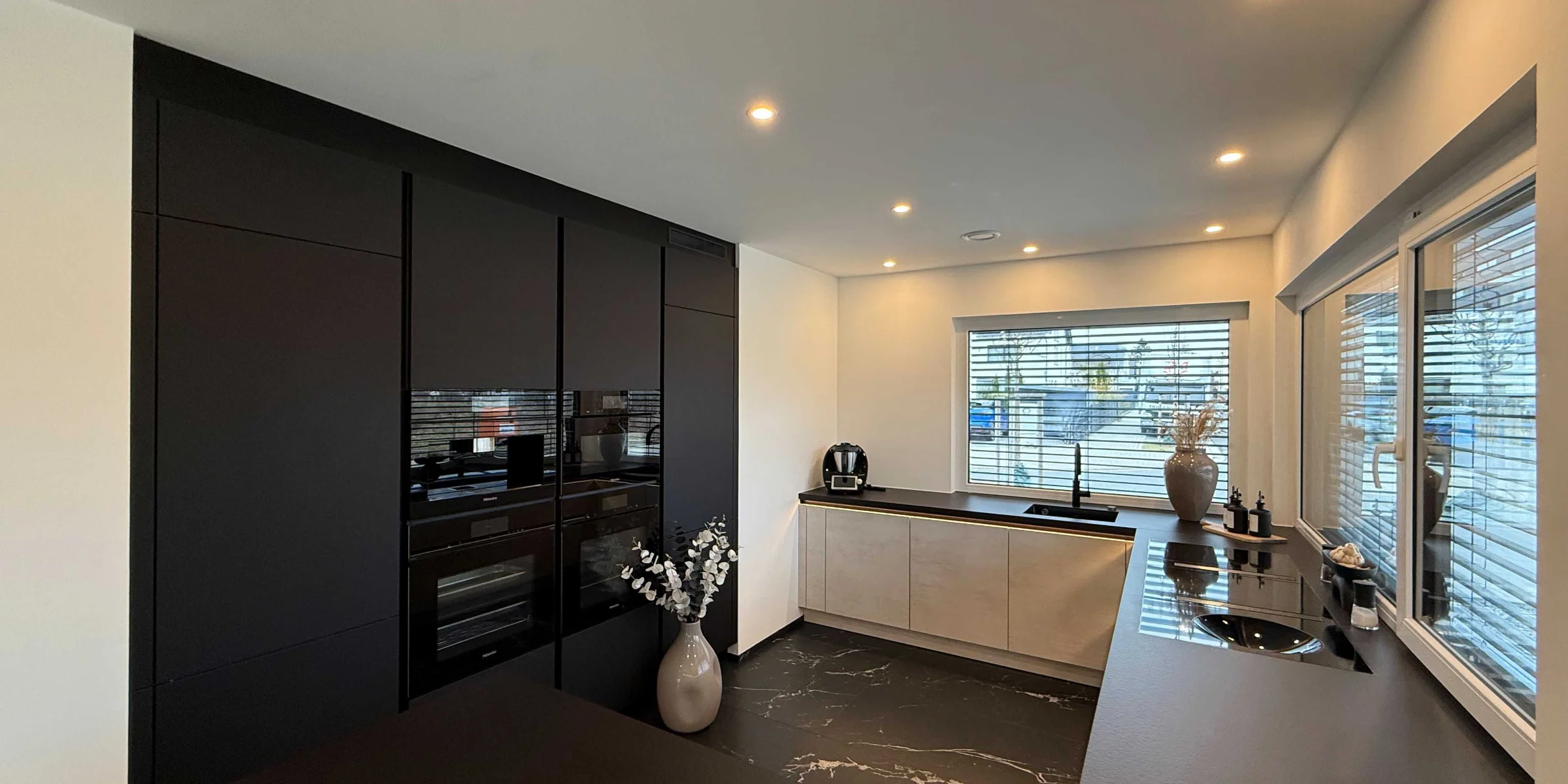 Cucina moderna con armadi scuri e isola centrale di Nolte Kitchen.