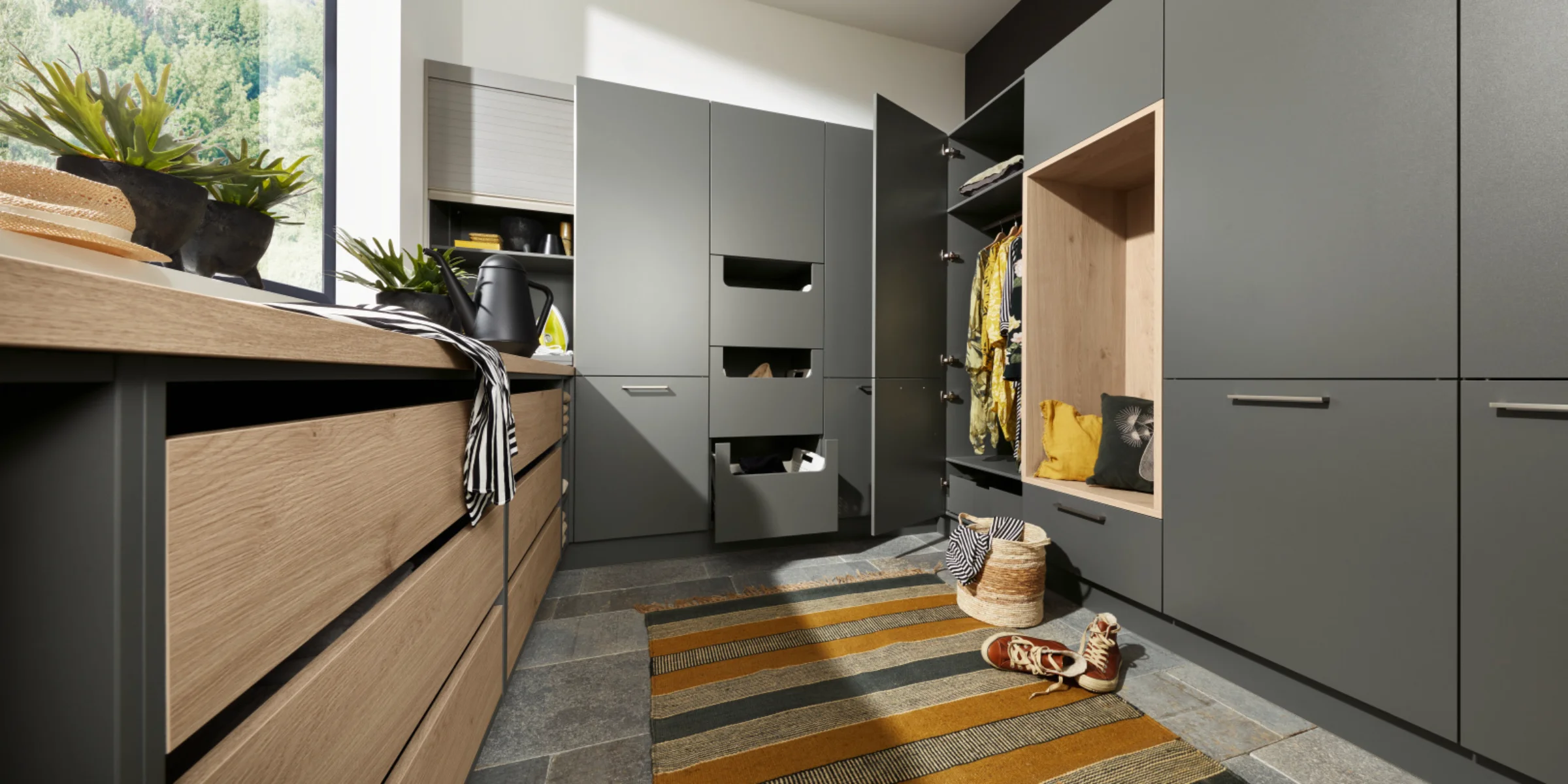 Una lavanderia con armadi e scaffali grigi, progettata da Nolte Utility Rooms.