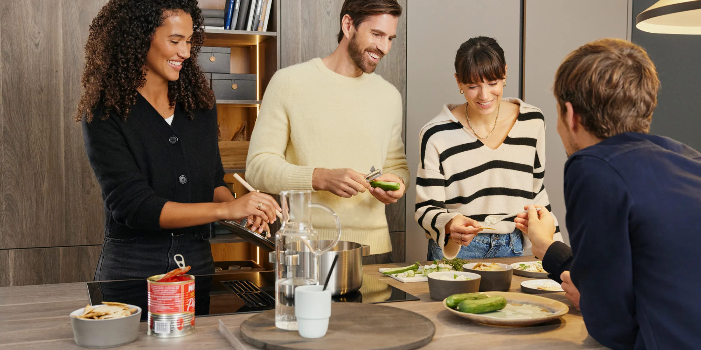 Un gruppo di persone cucina insieme in una moderna cucina Nolte.