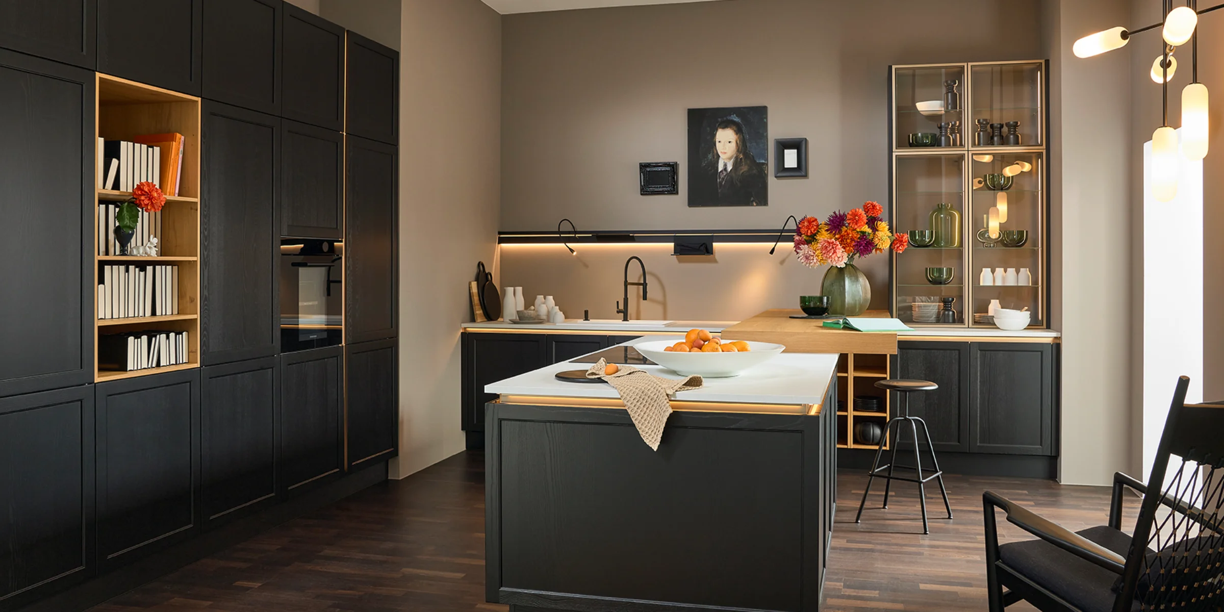 Cucina moderna con armadi scuri e piano chiaro, design di Nolte Kitchen.