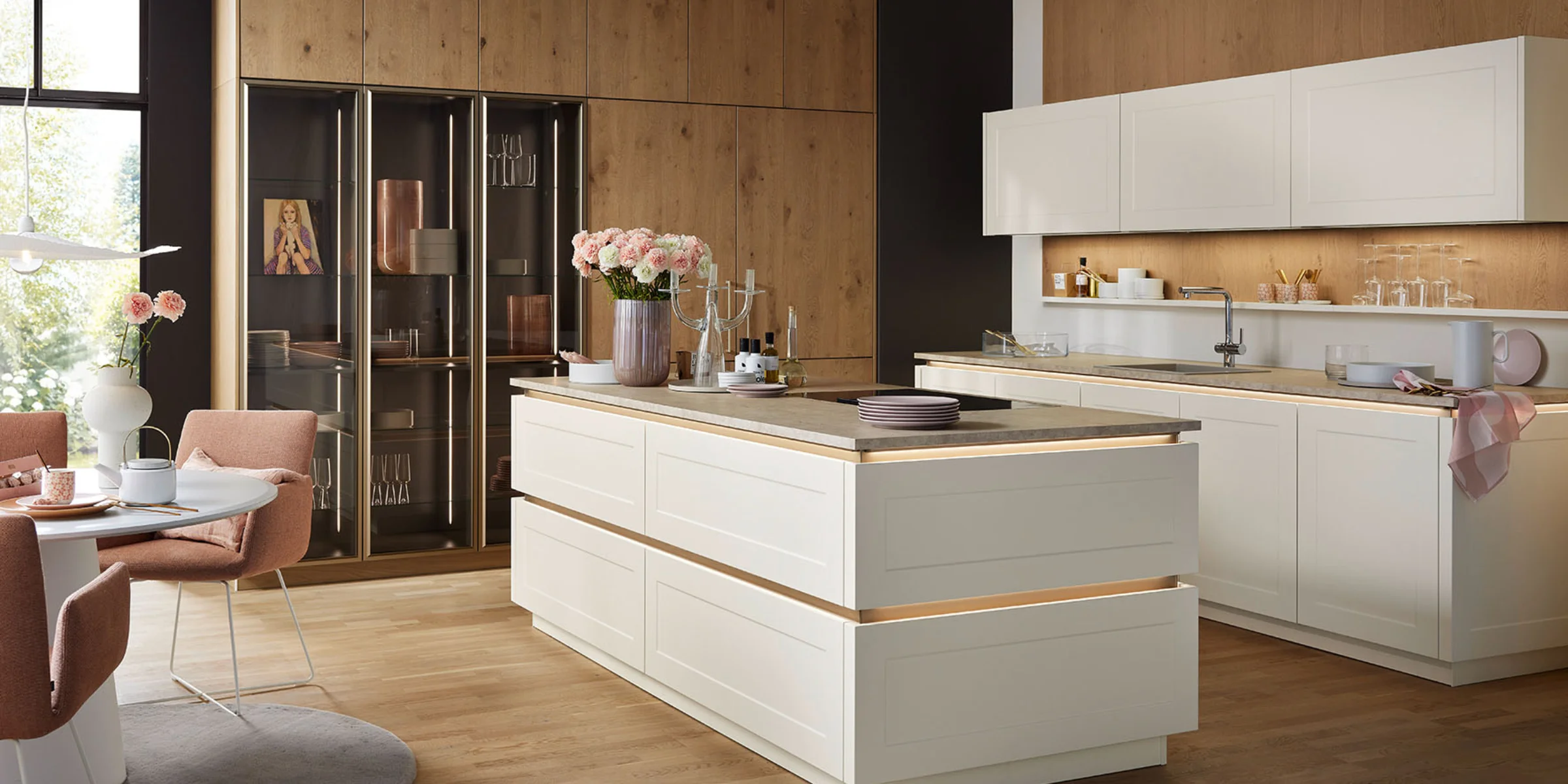 Cucina moderna con armadi bianchi e dettagli in legno di Nolte Kitchen.