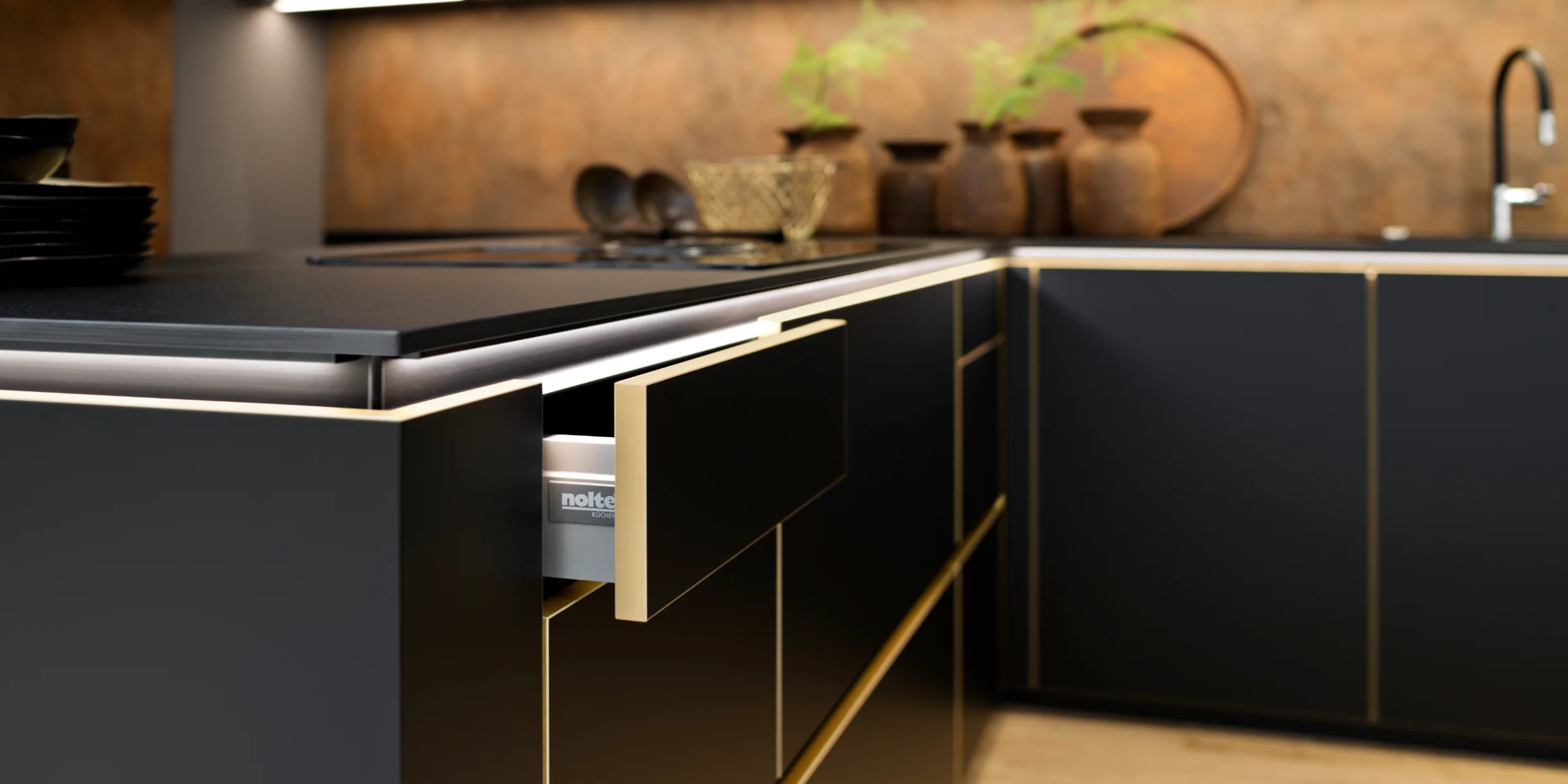 Cucina moderna con armadi neri e accenti dorati, design di Nolte Kitchen.